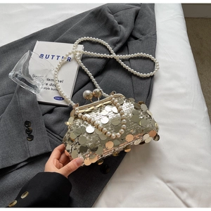 Close-up of silver sequin evening bag with large pearls and metallic chain details