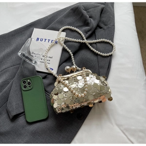 Detail of luxury sequin evening clutch bag with pearl strap and metal clip closure