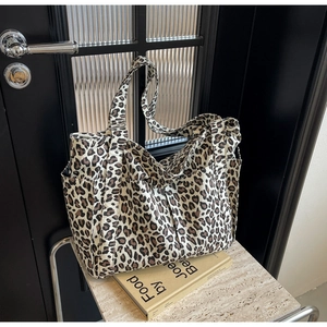 Vista dettagliata delle tasche laterali e dei manici della borsa tote in tela leopardata
