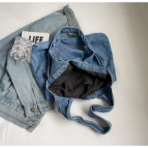 Flat lay of casual blue denim tote bag with interior pocket and magnetic closure