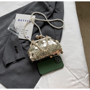 Detail of luxury sequined evening clutch with large pearls and long pearl chain strap