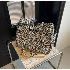 Dettaglio della borsa tote in tela leopardata con tasca laterale e robusti manici doppi