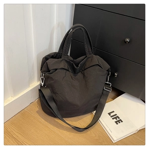 Gros plan du grand sac cabas noir en nylon plissé avec des boucles en métal argenté