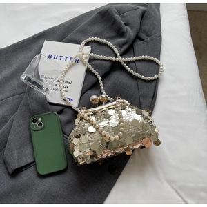 Detail of silver sequin evening clutch with pearl clasp and chain strap on grey blazer
