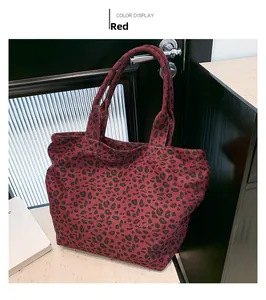 Detail view of large capacity tote bag with vibrant red leopard print and sturdy handles