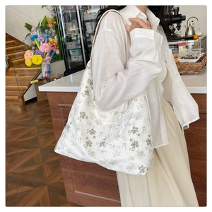 Détail d'un cabas floral en toile avec bordure en dentelle blanche dans un café