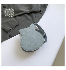 Detailed top view of a unique guitar-shaped crossbody bag in premium blue suede material