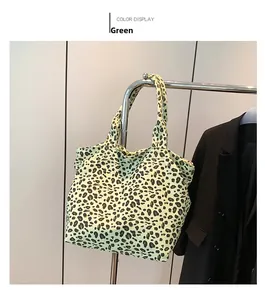 Close-up of green leopard print tote bag with soft fabric texture and wide handle