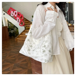 Grand sac fourre-tout en toile à motif floral vert porté à l'épaule pour un style décontracté