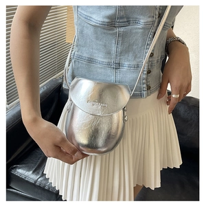 Detail of silver metallic saddle bag with Fashion & Bags text on casual denim outfit