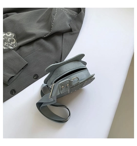 Detailed top view of light blue cat-shaped crossbody bag with wide shoulder strap