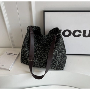 Close-up of leopard print canvas tote bag with adjustable brown leather shoulder strap