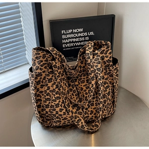Dettaglio della borsa tote in tela con stampa leopardata, tasca laterale e manici
