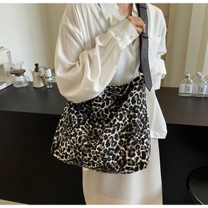 Close-up of leopard print canvas bag with adjustable brown leather shoulder strap