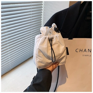 Detail of white mini nylon crossbody bag with drawstring closure and plaid texture