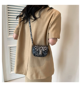 Rear view of a stylish leopard print mini crossbody bag worn with a neutral outfit