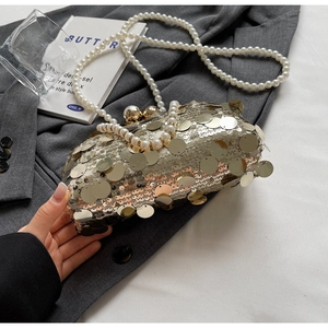 Detail of evening clutch bag featuring silver sequins and elegant double pearl metal clasp