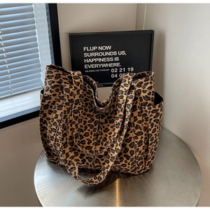 Dettaglio della borsa tote leopardata in tela con tasca laterale su supporto in metallo