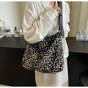 Detail of leopard print canvas tote bag with adjustable brown leather shoulder strap