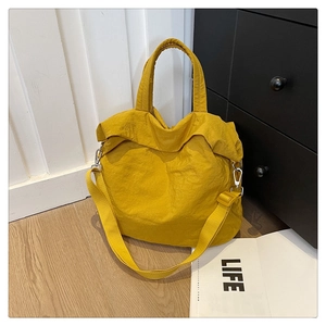 Détail du sac cabas jaune vif avec tissu à texture froissée et crochet en métal argenté