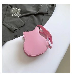 Detailed top view of pink guitar-shaped crossbody bag with fine stitching on white pedestal