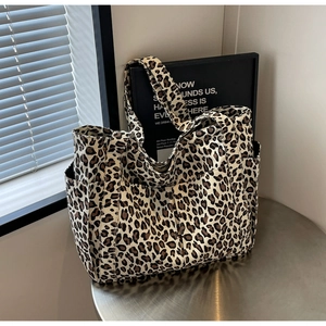 Dettaglio ravvicinato della borsa tote in tela leopardata con pratiche tasche laterali