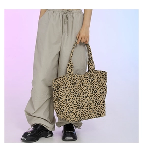 Detailed view of large leopard print canvas tote bag styled with street fashion outfit
