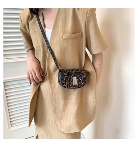 Detail of leopard print leather crossbody bag with metallic buckle and shoulder strap