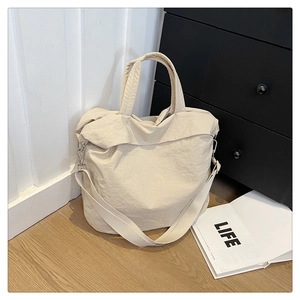 Gros plan du sac fourre-tout beige minimaliste avec crochets en métal et texture nylon