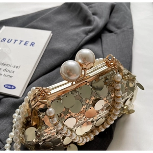 Detail of champagne gold sequin handbag with large pearl clasp and pearl chain handle