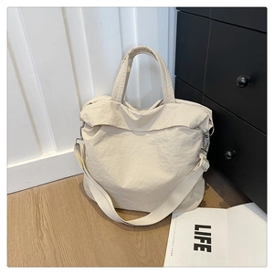 Vue détaillée du sac cabas en nylon blanc crème montrant la texture et les fermetures