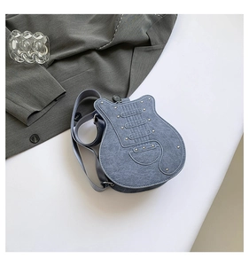 Detail of creative blue denim guitar shaped crossbody bag with metallic rivets and embroidery