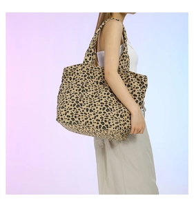 Detailed side view of the leopard print canvas tote bag on female model shoulder