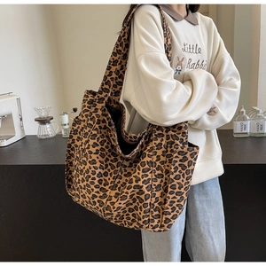 Dettaglio della borsa tote in tela leopardata con tasche laterali e grande capacità interna