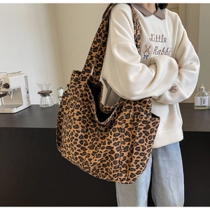 Dettaglio della borsa tote leopardata in tela con tasca laterale capiente e tracolla larga