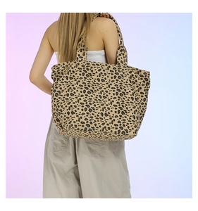 Detailed view of the large leopard print tote bag worn on shoulder for size reference