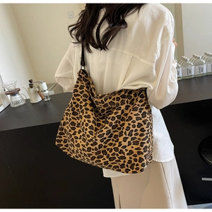 Close-up of leopard print hobo bag in durable canvas fabric on a modern cafe table