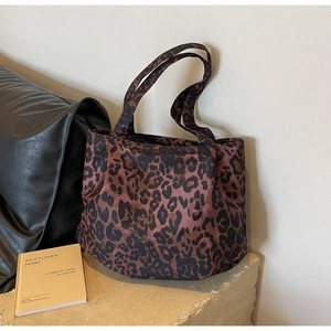 Close-up of leopard print canvas tote bag on stone pedestal for casual fashion look