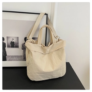 Détail du sac cabas beige minimaliste avec texture plissée et large bandoulière