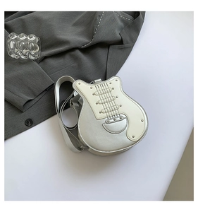 Close-up of creative guitar-shaped crossbody bag with silver metallic finish and rivets