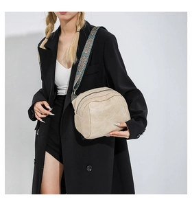 Detail der beigefarbenen Muscheltasche mit stilvollem Ethno-Muster Web-Schultergurt