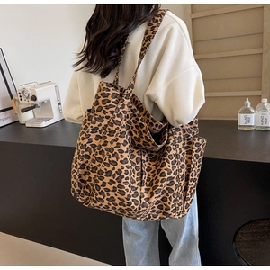 Grande borsa tote in tela con stampa leopardata indossata da una modella in stile casual