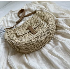 Detailansicht der Strohtasche mit braunem Lederriemen und Vintage-Metallschnalle