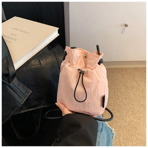 Detailed view of pink quilted nylon mini bucket bag with drawstring and thin strap
