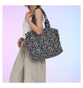 Detail view of the large capacity leopard print canvas tote bag on female model shoulder
