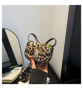 Close-up of leopard print crossbody bag featuring a gothic engraved silver metal lock