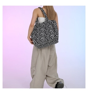 Close-up of a large floral print tote bag worn on shoulder for daily commute style