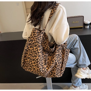 Vista dettagliata della borsa tote in tela leopardata con tasca laterale e tracolla