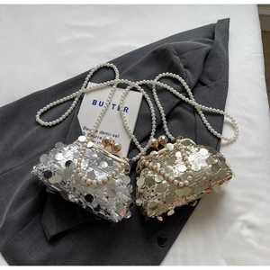 Detail of silver and gold sequin evening bags with pearl straps and metal clasps