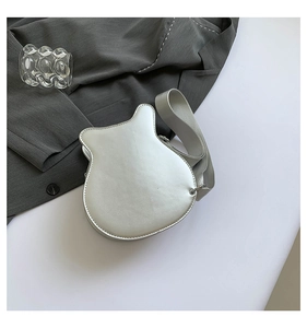 Macro shot of silver guitar shaped handbag with metallic finish and wide shoulder strap